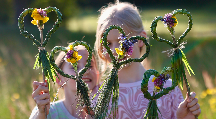 Two girls show their self-made grass hearts
