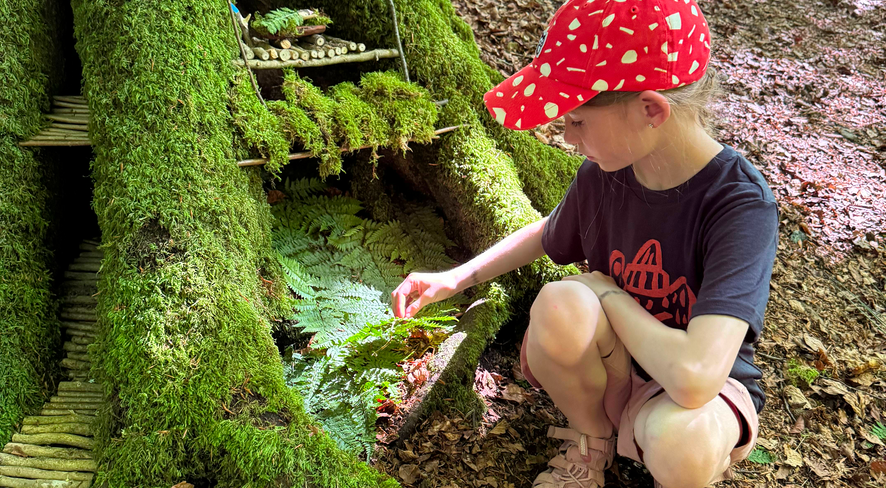 Girl builds a gnome hut in the forest