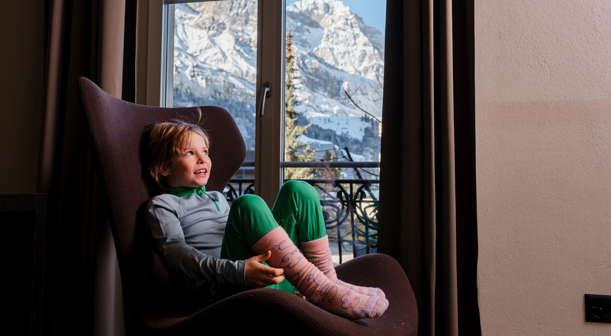 Child in namuk merino thermal underwear in a cozy chair