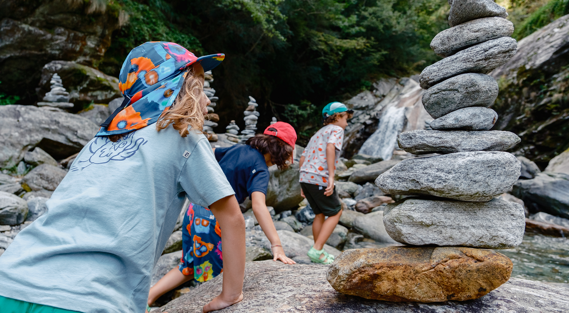 Children playing by the creek among the stones