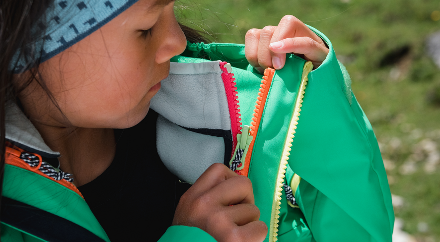 A girl unzipping the namuk zip-in jacket.
